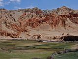 Mustang 03 04-1 Drakmar Red Cliffs and Entrance From Ghemi the trail heads up towards a ridgeline (3910m) and then traverses for about an hour when the red hills above Drakmar (3820m, Red Crag) come into view. The trail descends and crosses some terraced fields before nearing Drakmar with the entrance chortens visible on the right.